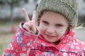 Portrait of little girl with Ukraine flag painted on her face showing Victory sign. Royalty Free Stock Photo