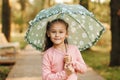 Portrait of a little girl with an umbrella in her hands on the background of the autumn park Royalty Free Stock Photo