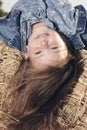 Portrait of a little girl upside down on a haystack