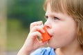 Portrait of little girl using asthma inhaler outdoors Royalty Free Stock Photo