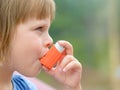 Portrait of little girl using asthma inhaler outdoors Royalty Free Stock Photo