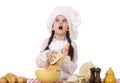 Portrait of a little girl in a white apron and chefs hat shred c Royalty Free Stock Photo