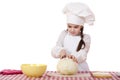 Portrait of a little girl in a white apron and chefs hat shred c Royalty Free Stock Photo