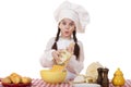 Portrait of a little girl in a white apron and chefs hat shred c Royalty Free Stock Photo