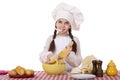 Portrait of a little girl in a white apron and chefs hat shred c Royalty Free Stock Photo