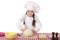 Portrait of a little girl in a white apron and chefs hat shred c Royalty Free Stock Photo