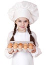 Portrait of a little girl in a white apron holding box of raw eg Royalty Free Stock Photo