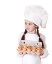 Portrait of a little girl in a white apron holding box of raw eg Royalty Free Stock Photo