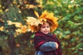 Portrait of a little girl in a wreath of autumn leaves