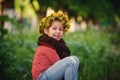 Portrait of a little girl in a wreath of dandelions in nature