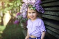 Portrait of a little girl with a wreath of lilac flowers on her head Royalty Free Stock Photo