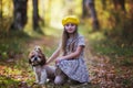 Portrait of a little girl in a yellow beret with a shit tsu dog against the backdrop of an autumnal forest Royalty Free Stock Photo