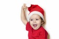 Happy girl in festive clothes and santa claus hat. Cute baby in Christmas clothes waits and enjoys the holiday. Royalty Free Stock Photo
