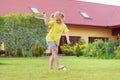 Portrait of little happy girl playing barefoot badminton at garden near her house Royalty Free Stock Photo