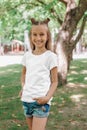 Portrait of a little happy girl in a white T-shirt in park Royalty Free Stock Photo