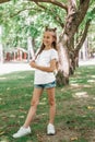 Portrait of a little happy girl in a white T-shirt in park Royalty Free Stock Photo