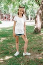 Portrait of a little happy girl in a white T-shirt in park Royalty Free Stock Photo