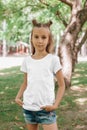 Portrait of a little happy girl in a white T-shirt in park Royalty Free Stock Photo