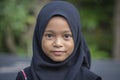 Portrait of a little indonesian muslim girl at the streets in Ubud, island Bali, Indonesia, close up