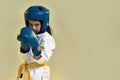 Portrait of little karate girl in white kimono wearing gloves and protective helmet, looking focused at camera, ready to Royalty Free Stock Photo