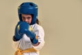 Portrait of little karate girl in white kimono wearing gloves and protective helmet, looking focused at camera, ready to Royalty Free Stock Photo