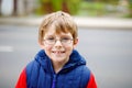 Portrait of little kid boy with glasses in colorful fashion fall clothing. Happy healthy child having fun outdoors. Cute