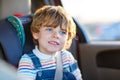 Portrait of little kid boy sitting in safety car seat Royalty Free Stock Photo