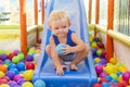 Portrait of little kid playing ball pit and enjoying time in kids entertainment and play area. Happy kid plays in kindergarten