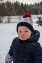 Portrait of a little offended child with winter outdoor landscape on background