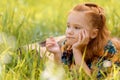 portrait of little pensive child resting on green grass