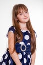 Portrait of a little positive schoolgirl in a polka dot dress