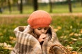 Portrait Little Preschool Minor Baby Girl In Orange Beret On Yellow Fallen Leaves Wrapped In Blanket Warms Hands With Royalty Free Stock Photo