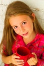 Portrait of little pretty smiley girl with cup in hands drinking