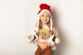 Portrait of little pretty girl in Santa hat with teddy bear isolated on white background. Happy Christmas holidays, cute child in Royalty Free Stock Photo