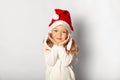 Portrait of little pretty little girl in Santa hat isolated on white background. Happy Christmas holidays, cute child in happiness Royalty Free Stock Photo