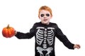 Portrait of little red haired boy wearing halloween skeleton costume and holding pumpkin Royalty Free Stock Photo