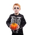 Portrait of little red haired boy wearing halloween skeleton costume and holding pumpkin Royalty Free Stock Photo