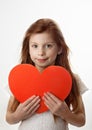 Portrait of little red haired girl with big red heart in her hands Royalty Free Stock Photo