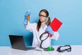 Portrait of little school girl, kid in white big gown as chemist, scientist chemical equipment, fluid in laboratory