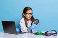 Portrait of little school girl, kid in white big gown as chemist, scientist chemical equipment, fluid in laboratory