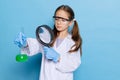 Portrait of little school girl, kid in white big gown as chemist, scientist chemical equipment, fluid in laboratory