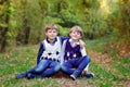 Portrait of little school kids boys sitting in forest. Happy children, best friends and siblings having fun on warm Royalty Free Stock Photo