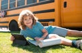 Portrait of little schoolboy writing outdoor in school park and doing homework. Royalty Free Stock Photo