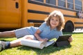 Portrait of little schoolboy writing outdoor in school park and doing homework. Royalty Free Stock Photo