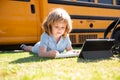 Portrait of little schoolboy writing outdoor in schoolyard park and doing homework. Royalty Free Stock Photo