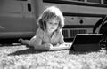 Portrait of little schoolboy writing outdoor in schoolyard park and doing homework. Royalty Free Stock Photo