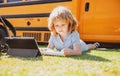 Portrait of little schoolboy writing outdoor in schoolyard park and doing homework. Royalty Free Stock Photo