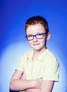 Portrait of a little smiling boy in a funny glasses and tie. Back to school. Smart boy using microscope over blue Royalty Free Stock Photo