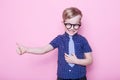 Portrait of a little smiling boy in a funny glasses and tie. School. Preschool. Fashion. Studio portrait over pink background Royalty Free Stock Photo