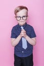 Portrait of a little smiling boy in a funny glasses and tie. School. Preschool. Fashion. Studio portrait over pink background Royalty Free Stock Photo